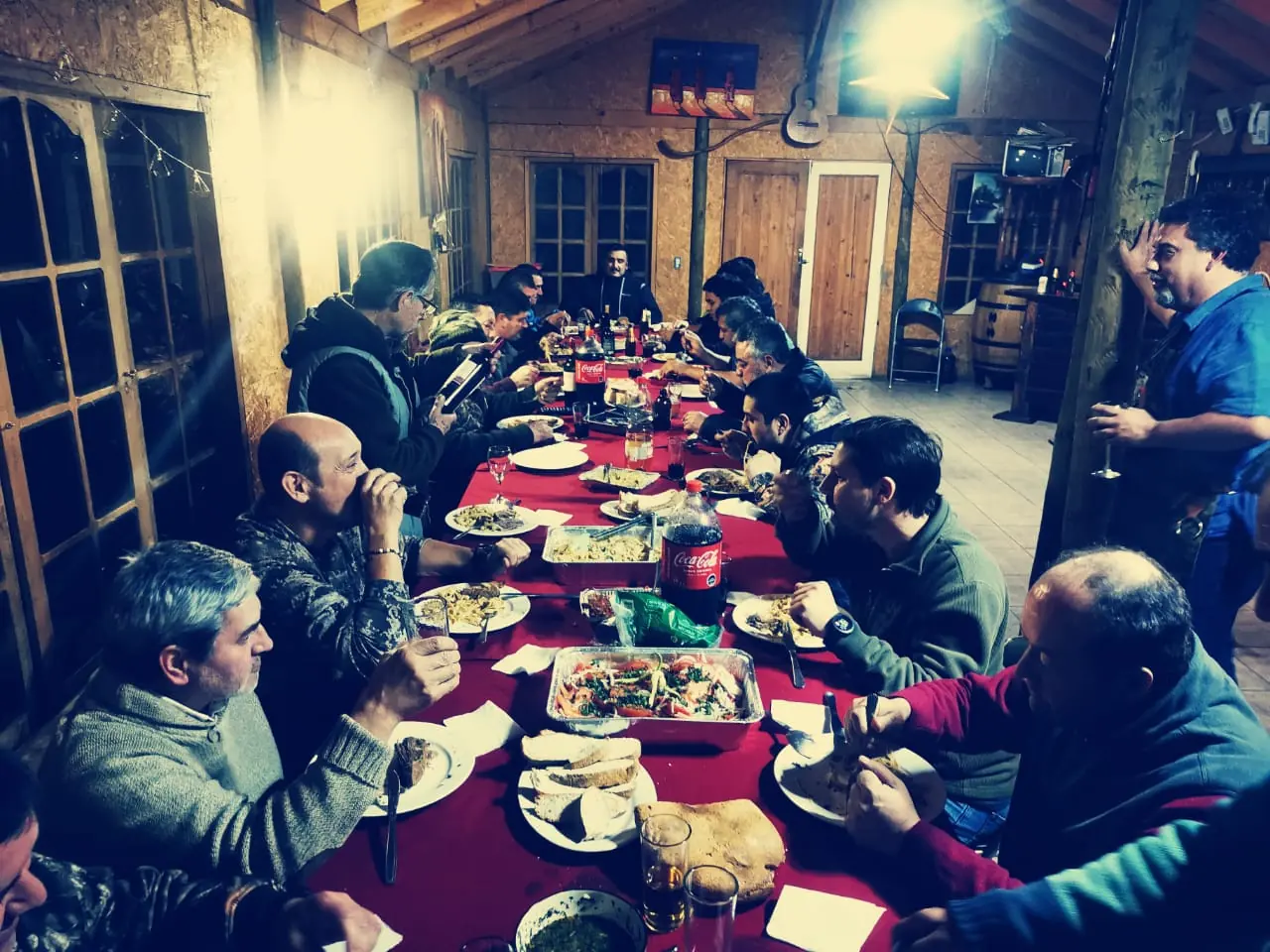 Socios del club en una mesa larga durante la cena de aniversario en la casa del club
